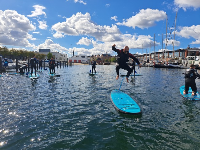 Polterabend med sup surfing i Århus - Garanti for vand i håret og store surfer smil!